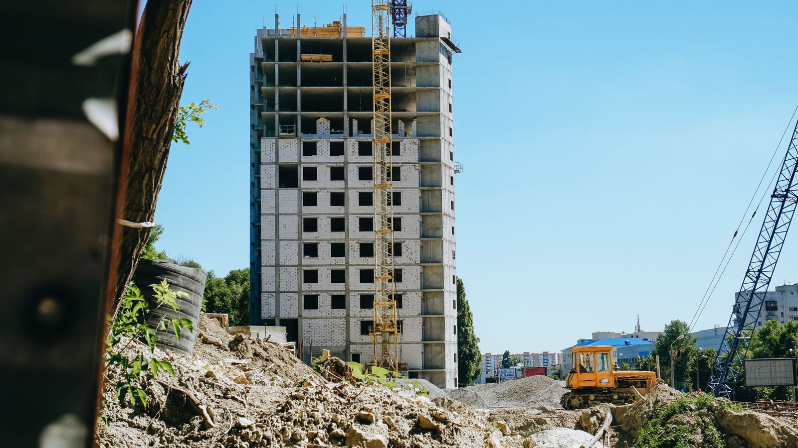 Mid-rise building under construction with tower cranes, showing the scale of general contractor projects