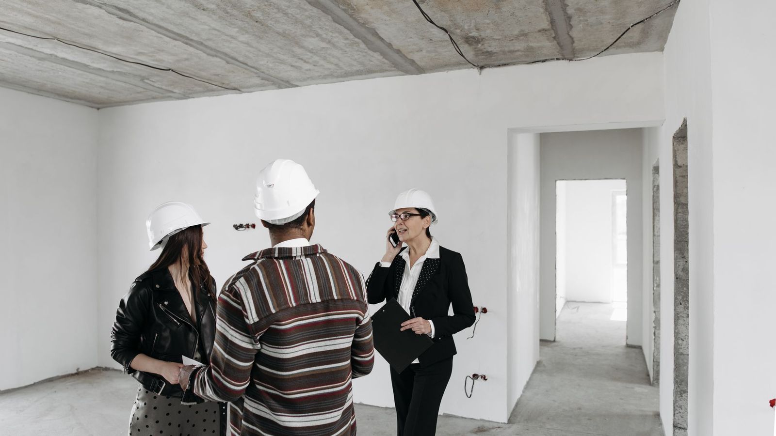 General contractor meeting with homeowners inside a new construction home to discuss the project