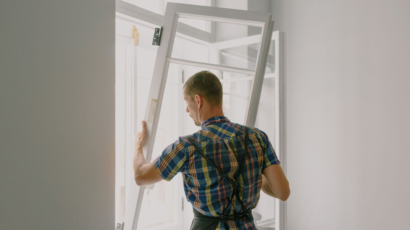 Window installer mounting a new window frame in a home